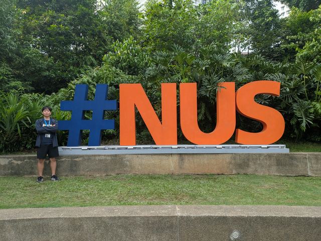 シンガポール国立大学（NUS）のモニュメント前に立つ創業メンバー・奥河
